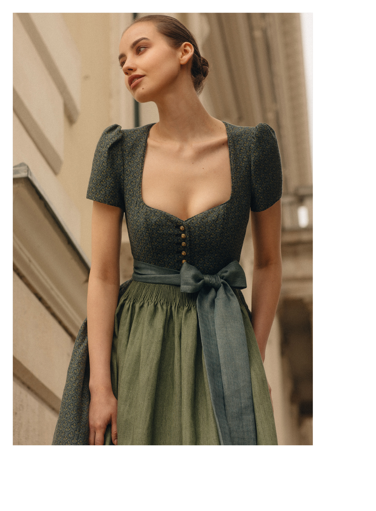 Frauenmodel in blau/ grün gemustertem Ärmchen Dirndl mit Herzausschnitt und grüner Schürze