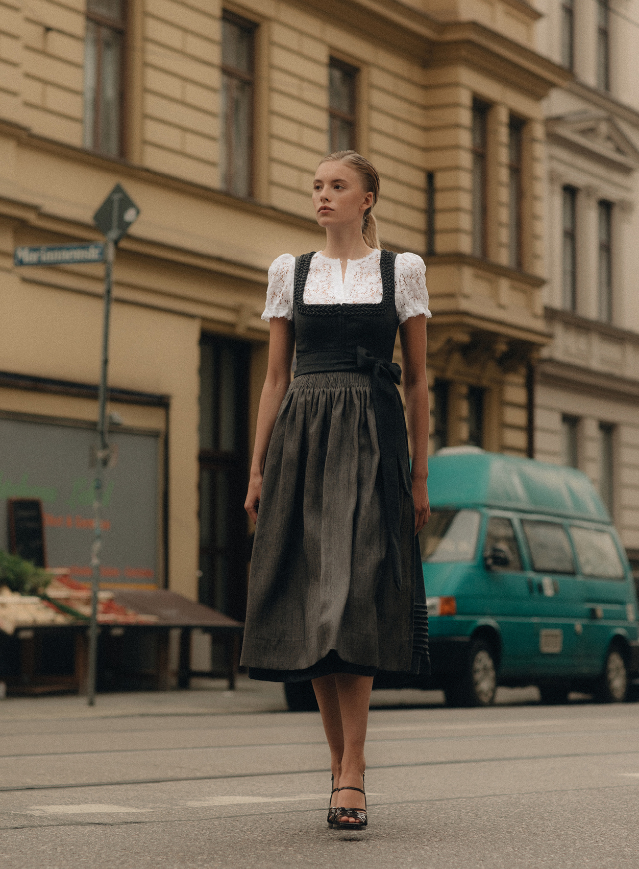 Frauenmodel in Dirndl mit Herzrüschen, passender Schürze und hochgeschlossener Spitzenbluse